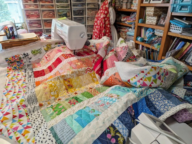 Rainbow Scrap Quilt in-progress, featuring scrap fabrics in pink, red, orange, yellow, green, aqua, blue, purple, and white.