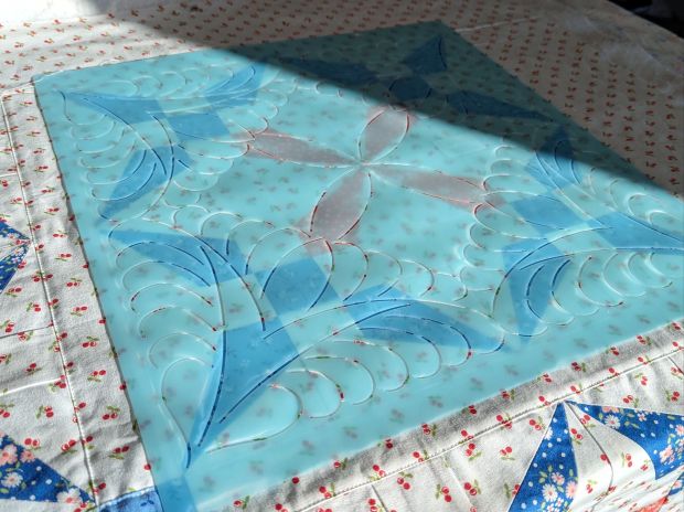 Quilting stencil atop the King David’s Crown quilt pattern in Cali & Co. fabric, made by That Crafty Cara (Cara Brooke) for Fat Quarter Shop