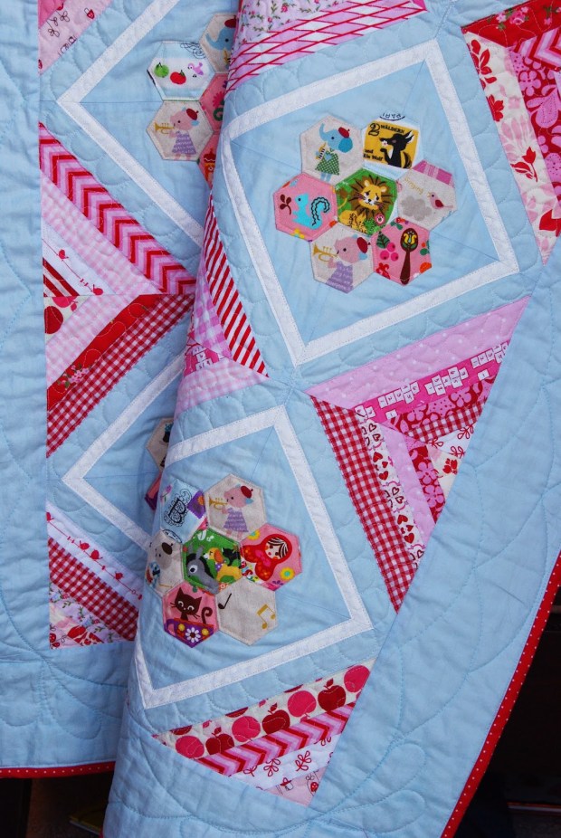 Storybook Hexagon Quilt made by Cara Brooke of That Crafty Cara. A baby quilt with EPP hexagon blossoms set with string blocks.