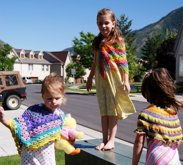 Three handmade shawls that Cara Brooke of That Crafty Cara made for her daughters when they were young girls.