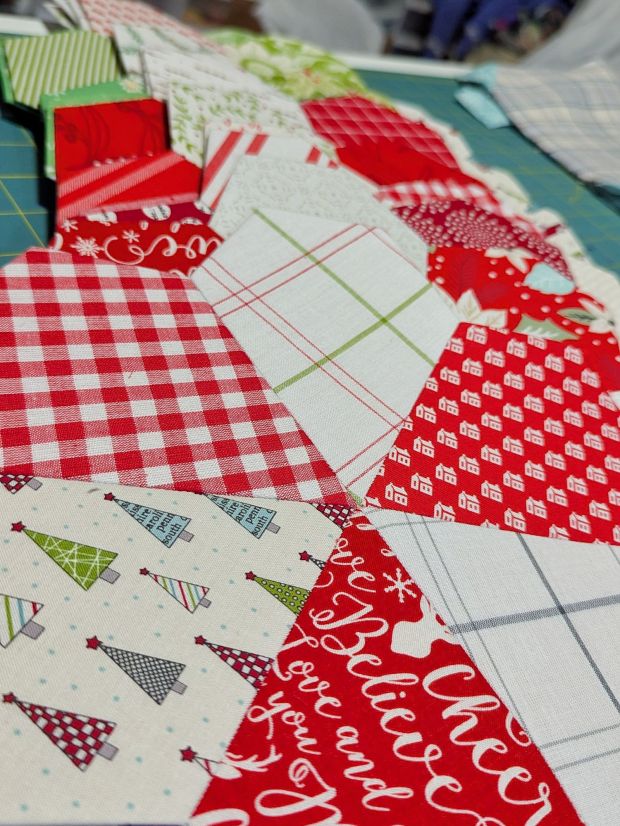 English Paper Piecing quilt blocks that look like red, green, and white peppermint candy discs