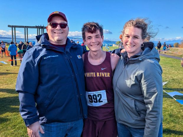 Nathaniel Brooke of White River High School smiles with his parents after completing a cross country meet in 2025
