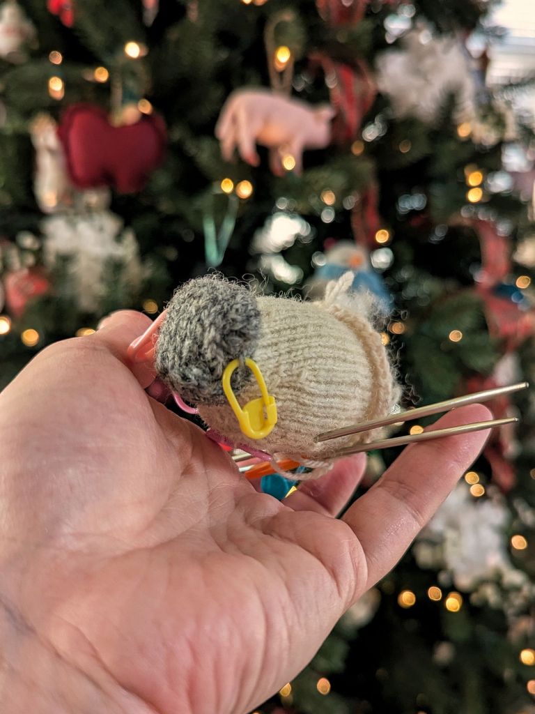 Wee Woolly Sheep knitted Ornament in-progress, made with gray and white yarn.