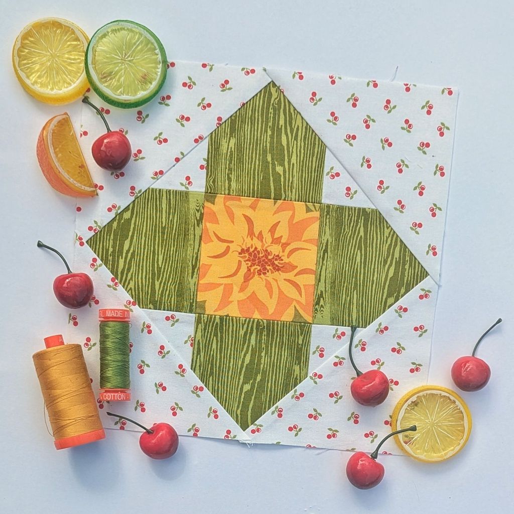 Sewcialites 3 Block #9 Daylight made with green, yellow, and cherry print fabrics.